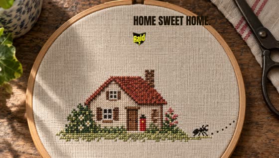 Cross-stitch sampler cottage with a tiny stitched Raid can